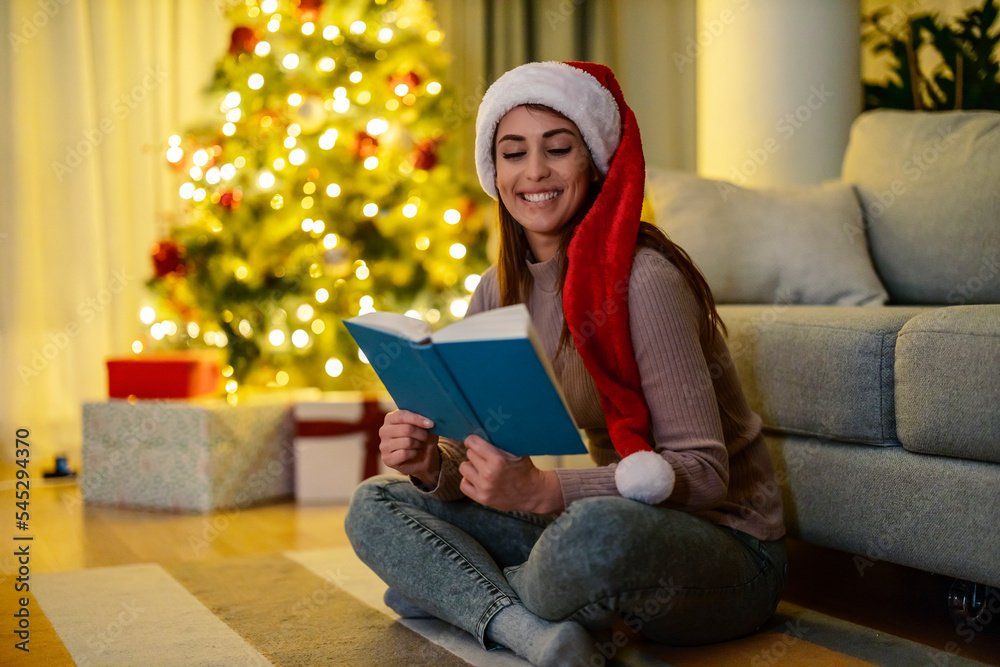Girl reading next to a Christmas tree Girl reading next to a Christmas tree