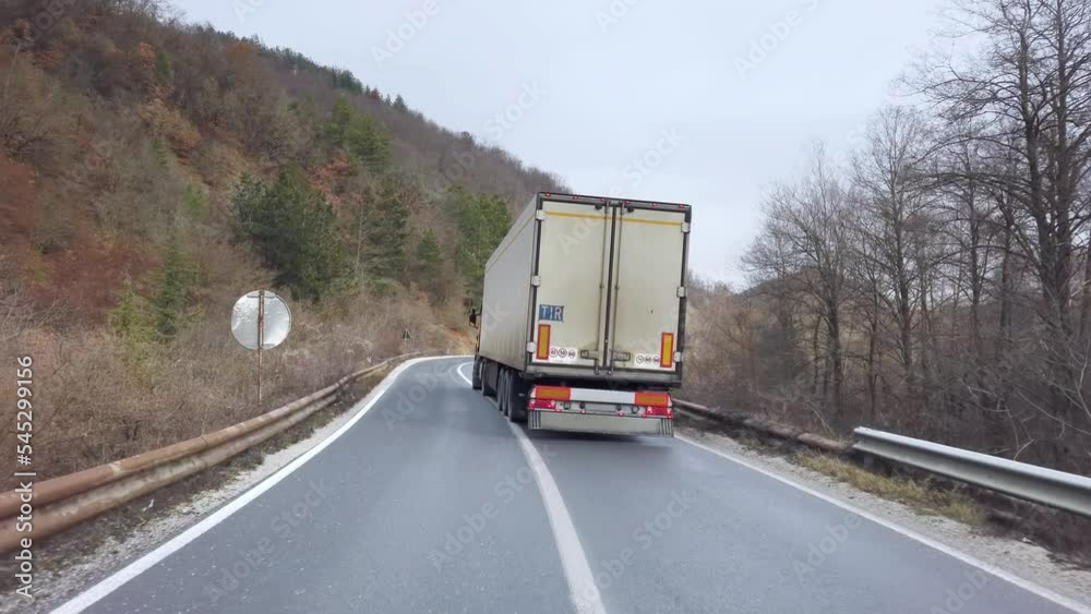 Lorry truck drigin on the winding rural road in autumn Lorry truck drigin on the winding rural road in autumn