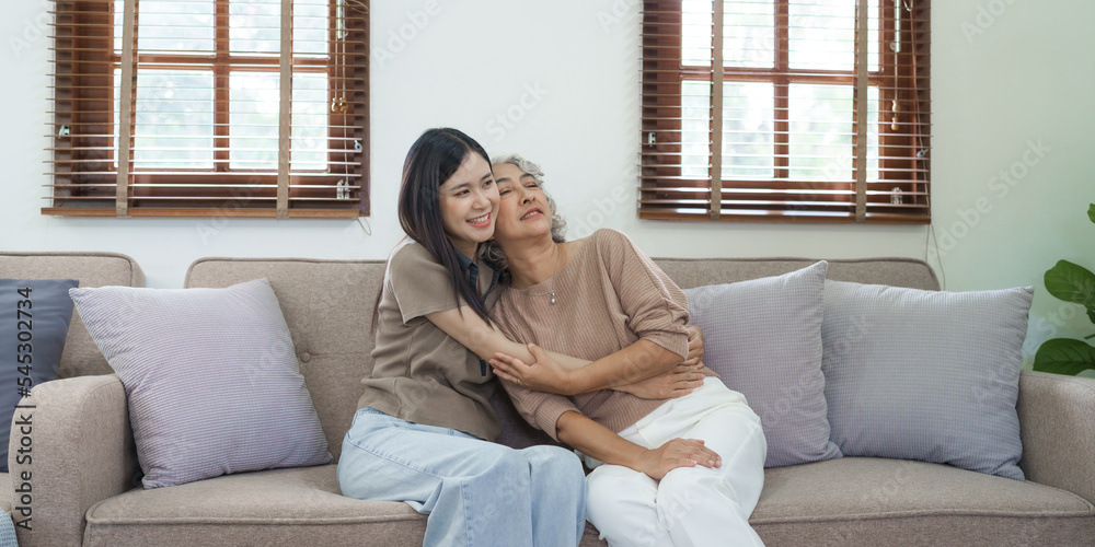 Portrait loving adult asian people daughter and senior mature mom hugging on couch. Portrait loving adult asian people daughter and senior mature mom hugging on couch.
