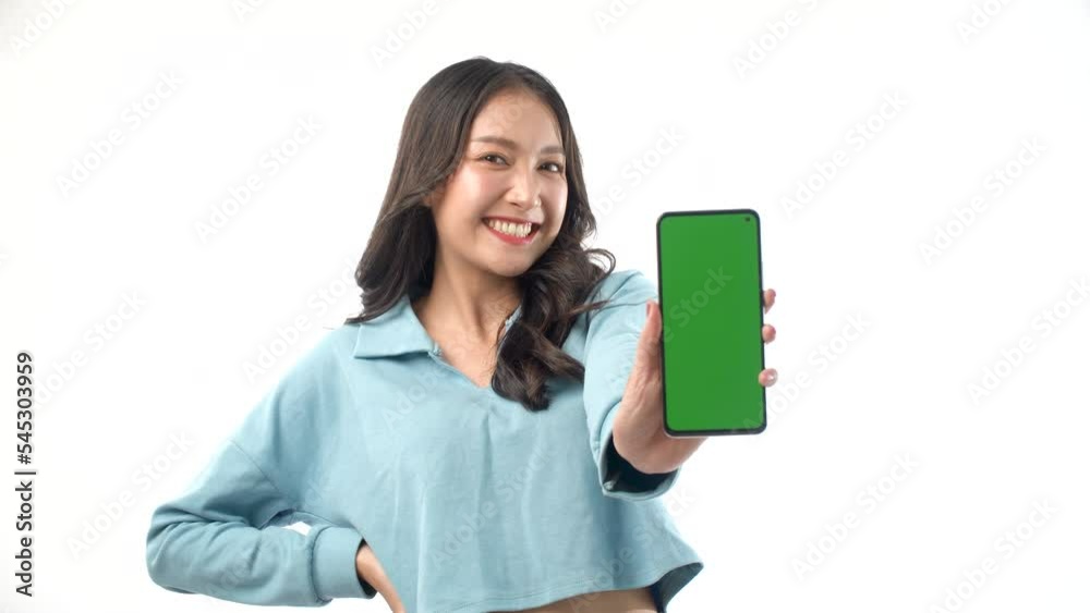 Excited surprised Asian woman showing thumbs up and green screen mobile phone for shopping online on white background. Shock girl wear casual holding thumbs up show empty touch screen on smartphone. Excited surprised Asian woman showing thumbs up and green screen mobile phone for shopping online on white background. Shock girl wear casual holding thumbs up show empty touch screen on smartphone.