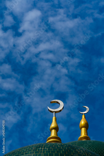 Fototapeta Crescent moon of Muslim mosque with blue sky background