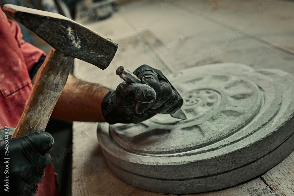 The craftsman works with stone with different tools. atmospheric photo. Sculpture making, handmade - obrazy, fototapety, plakaty 