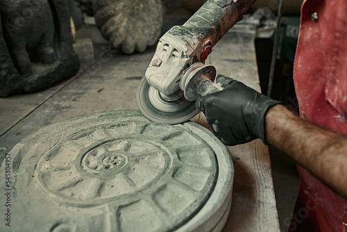 The craftsman works with stone with different tools. atmospheric photo. Sculpture making, handmade