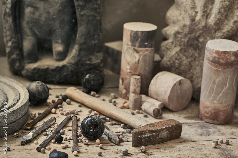 background with various tools for working with stone. Stone sculptures in the background in the workshop. hand made