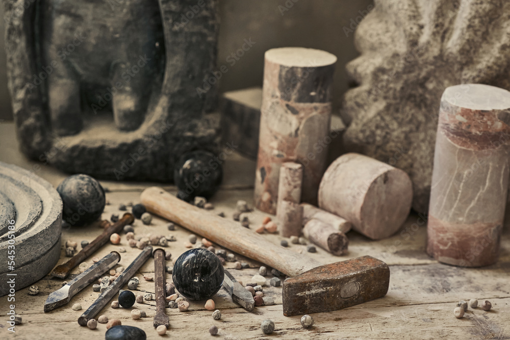 background with various tools for working with stone. Stone sculptures in the background in the workshop. hand made background with various tools for working with stone. Stone sculptures in the background in the workshop. hand made