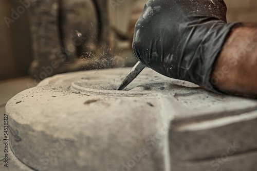 Obraz na plátně The craftsman works with stone with different tools