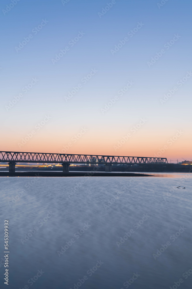Fototapeta premium 朝日に染まる河川敷と鉄橋