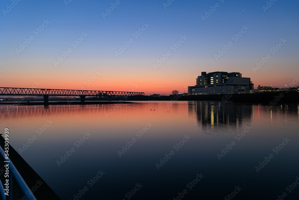 Fototapeta premium 朝日に染まる河川敷と鉄橋