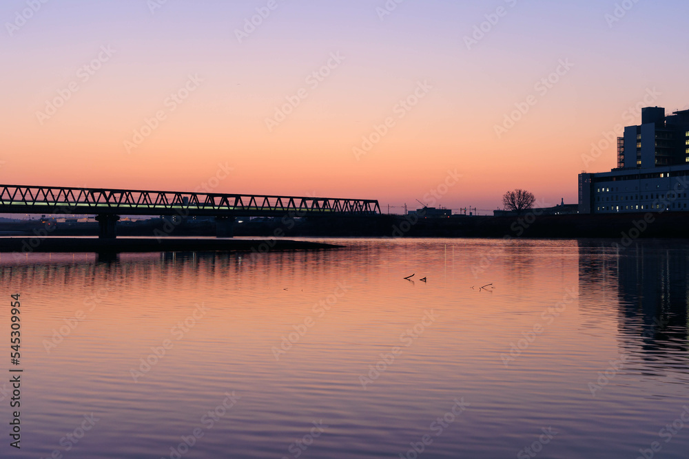 朝日に染まる河川敷と鉄橋