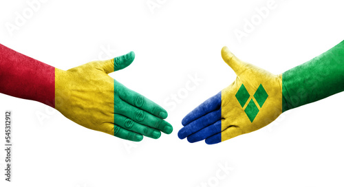 Handshake between Saint Vincent Grenadines and Guinea flags painted on hands, isolated transparent image.