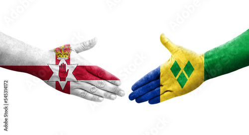 Handshake between Saint Vincent Grenadines and Northern Ireland flags painted on hands, isolated transparent image. photo