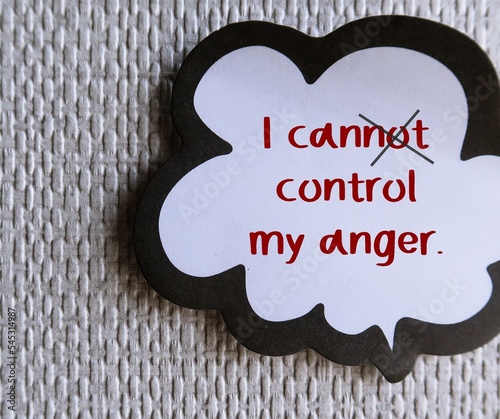 Speech balloon stick on wall background with handwritten text I CANNOT CONTROL MY ANGER, crossed off to I CAN, means to overcome negative self talk, change viewpoint and practice anger management