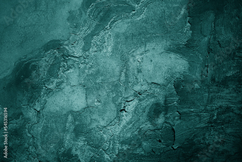 Old green concrete wall surface. Сrumbled. Close-up. Dark teal rough background for design.