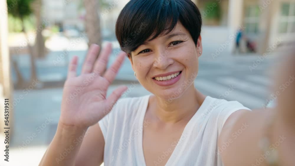 Middle age chinese woman smiling confident having video call at street Middle age chinese woman smiling confident having video call at street