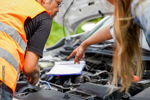 Closeup and crop motor vehicle mechanic checking engine according to customer orders on blurred background.