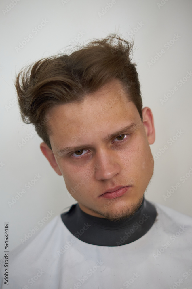 portrait of a young stylish guy dark haired European appearance close up, in a barbershop, model haircut, white background portrait of a young stylish guy dark haired European appearance close up, in a barbershop, model haircut, white background