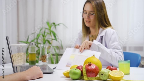 The nutritionist gives the diet program to the patient. Healthy lifestyle.
The dietitian gives her patient a diet program for a healthy life.
 photo