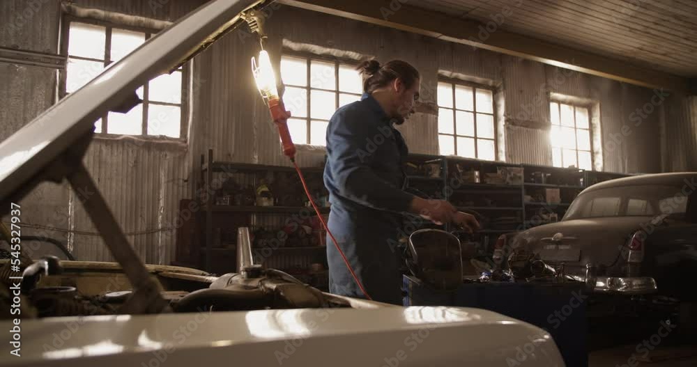 Man repairing car under sunlight Man repairing car under sunlight