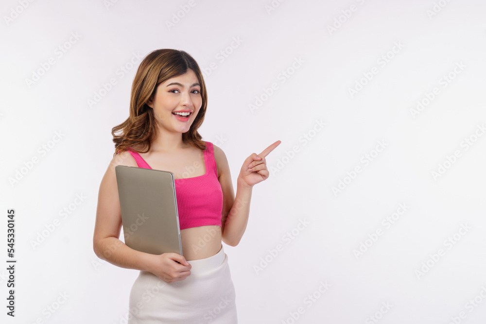 Portrait of young woman holding laptop computer and pointing finger aside isolated over white background Portrait of young woman holding laptop computer and pointing finger aside isolated over white background