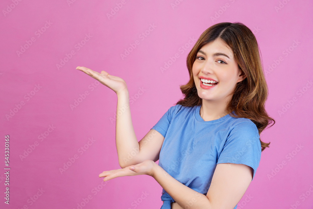 Portrait of excited young woman wearing casual t-shirt hold hand demonstrate offer ads promo isolated over pink background Portrait of excited young woman wearing casual t-shirt hold hand demonstrate offer ads promo isolated over pink background