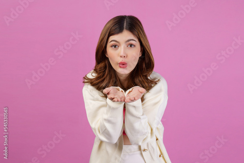 Portrait of Surprised young woman presenting or showing open hand palm with copy space for product over isolated pink background © Johnstocker