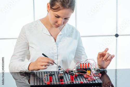 girl student experimenting with an optical electronic setup to study the optical properties of natural crystals