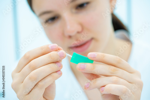 Young woman laboratory assistant mount lab on chip LOC microfluidics device