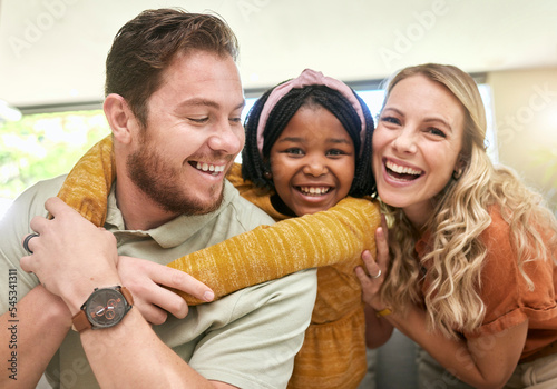 Family, children and adoption with a girl, mother and father bonding in the living room of their home. Portrait, love and smile with happy foster parents and black daughter together in a house photo