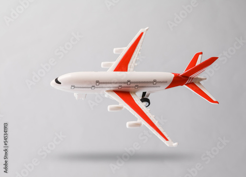 Airplane model hovering on a gray background with a shadow. Travel concept