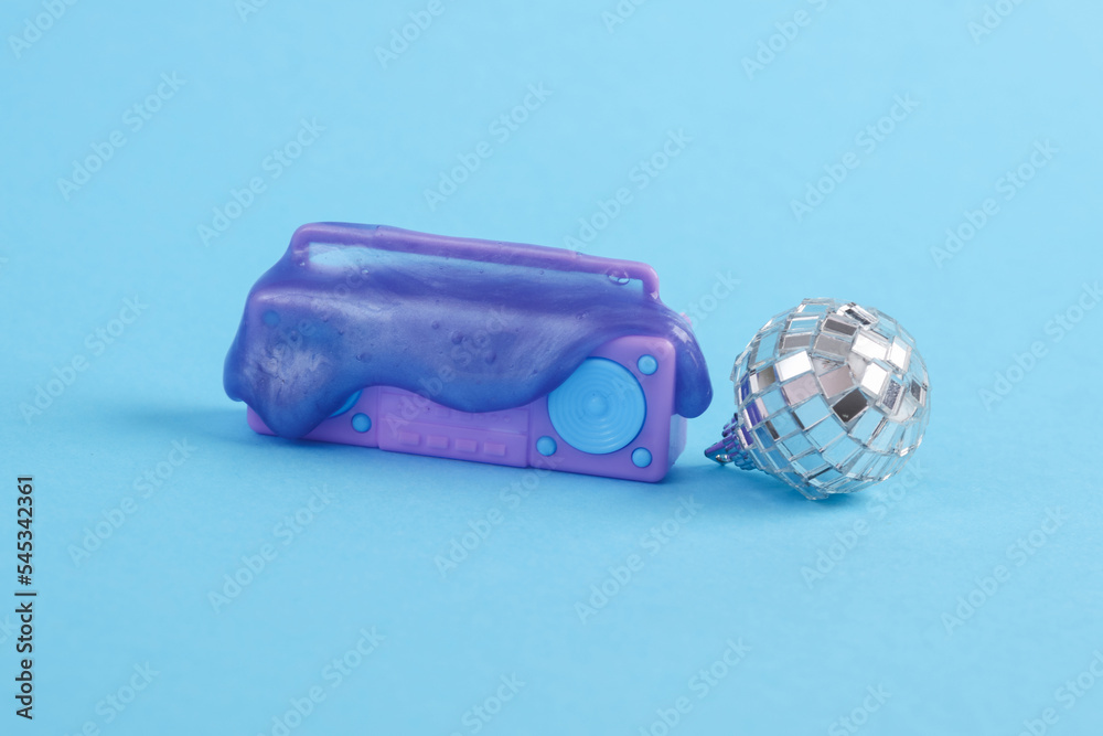 Plastic miniature boombox audio player with slime and disco ball on a blue background. Party concept Plastic miniature boombox audio player with slime and disco ball on a blue background. Party concept