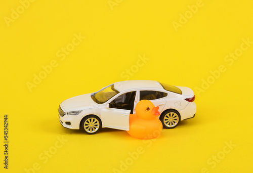 Rubber duck with a car on a yellow background. Driving concept © splitov27