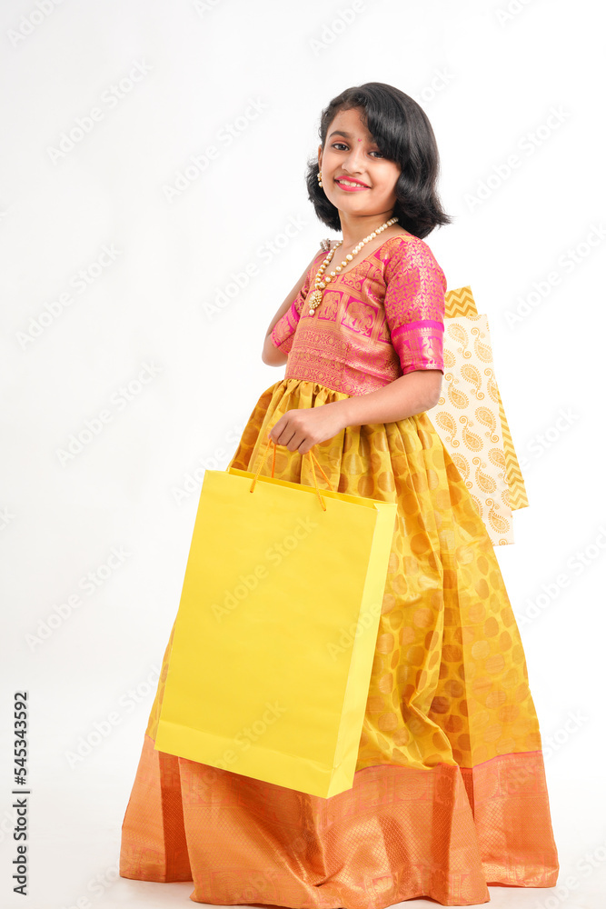 Happy Indian little girl holding shopping bags on white background. Happy Indian little girl holding shopping bags on white background.