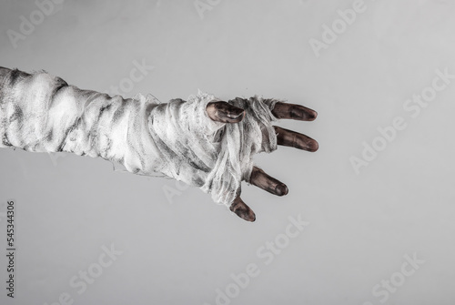 Mummy's hand wrapped in a bandage isolated on a black background. Halloween concept