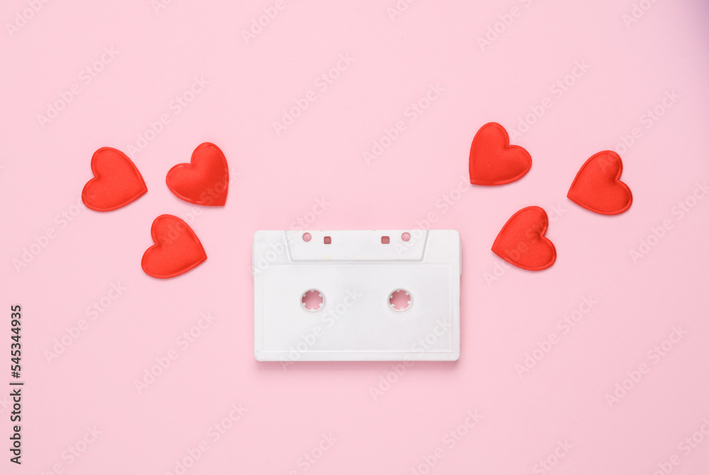 White audio cassette with hearts on pink background. Romantic music, love, valentine's day concept White audio cassette with hearts on pink background. Romantic music, love, valentine's day concept