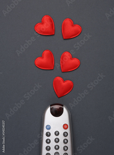 Tv remote with hearts on gray background
