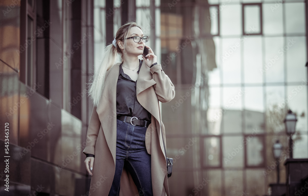 Young blonde woman talking on the phone in urban location. Lifestyle