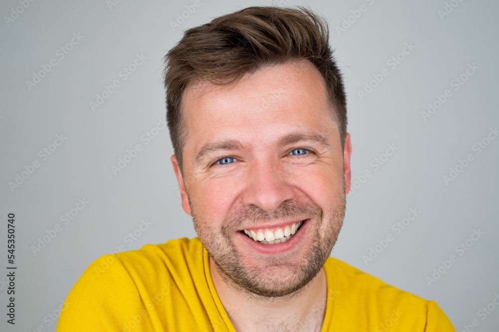 Obraz premium Handsome young man smiling while standing isolated on white background