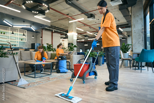 Foto Employees cleaning company performs general cleaning of a coworking space
