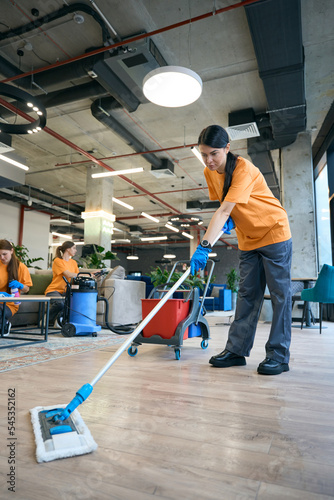 Cleaning company employees use a professional vacuum cleaner, a special mop