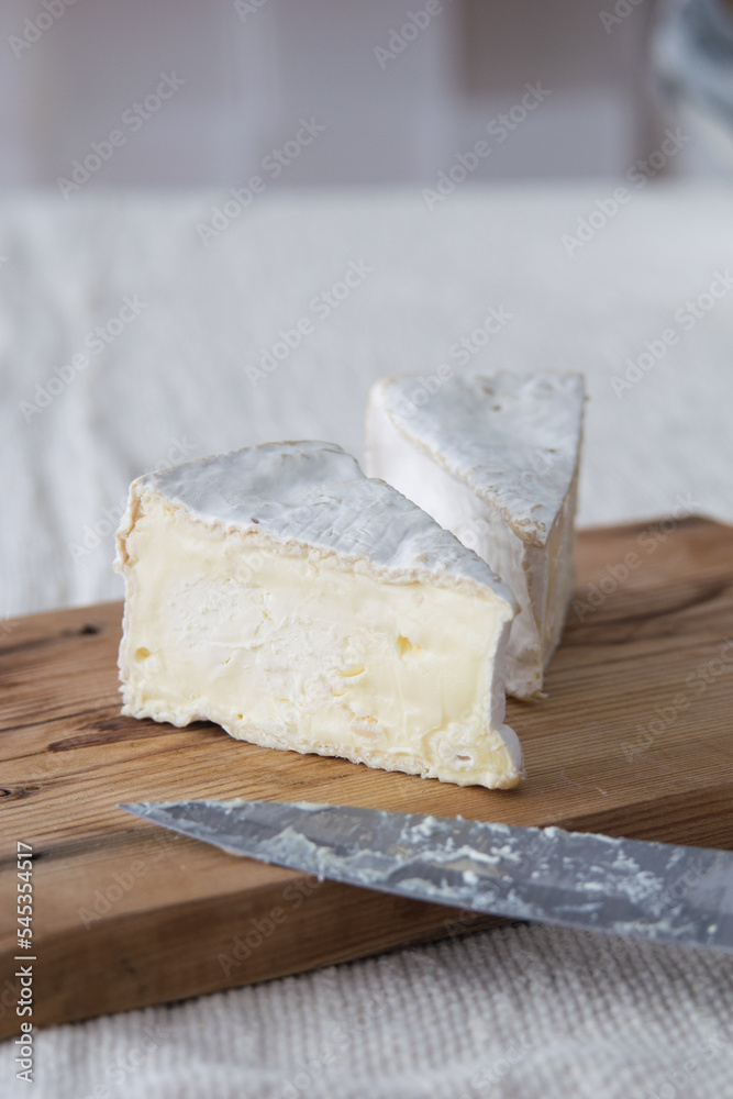 Piece of camamber brie cheese on wooden board. Selective focus