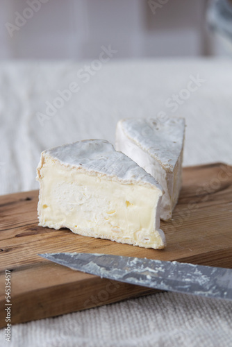 Piece of camamber brie cheese on wooden board. Selective focus