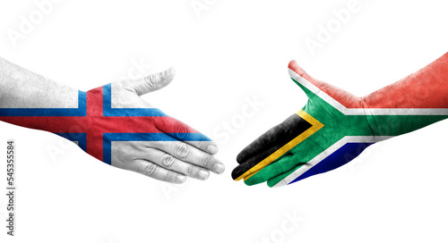 Handshake between South Africa and Faroe Islands flags painted on hands, isolated transparent image.