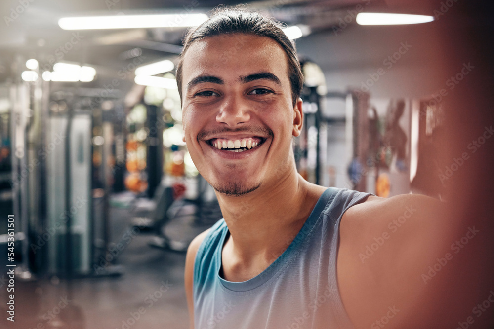 Portrait of man, gym selfie and fitness influencer workout for motivation, sports cardio exercise and wellness training. Happy smile, athlete building muscle and healthy weight lifting for strength