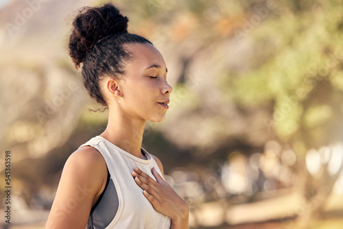 Black woman, breath and hand on chest, for meditation and wellness being peaceful to relax. Bokeh, African American female and lady outdoor, in nature and being calm for breathing exercise and health photo
