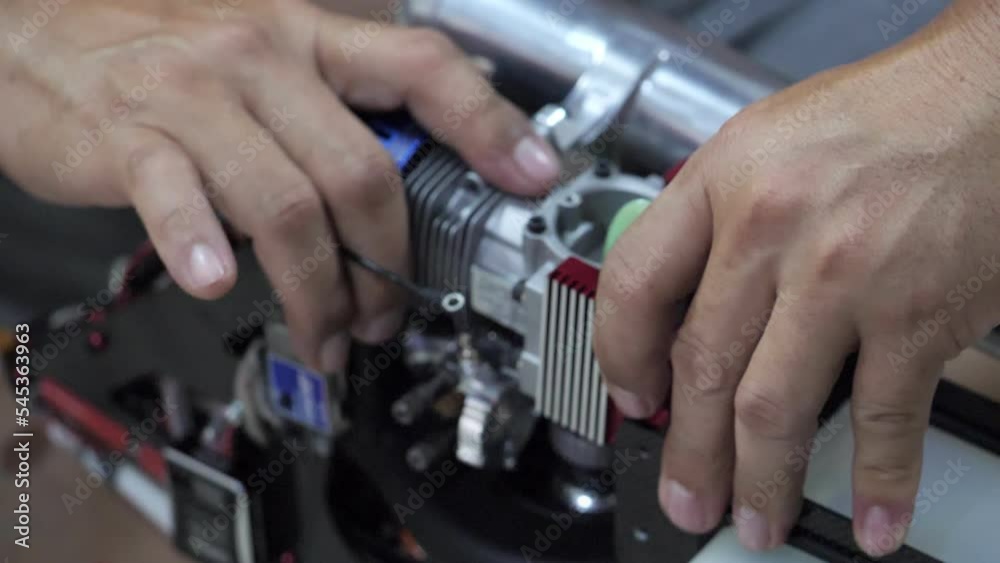 Man's hand holding the engine of an RC plane, he is repairing it. Man's hand holding the engine of an RC plane, he is repairing it.