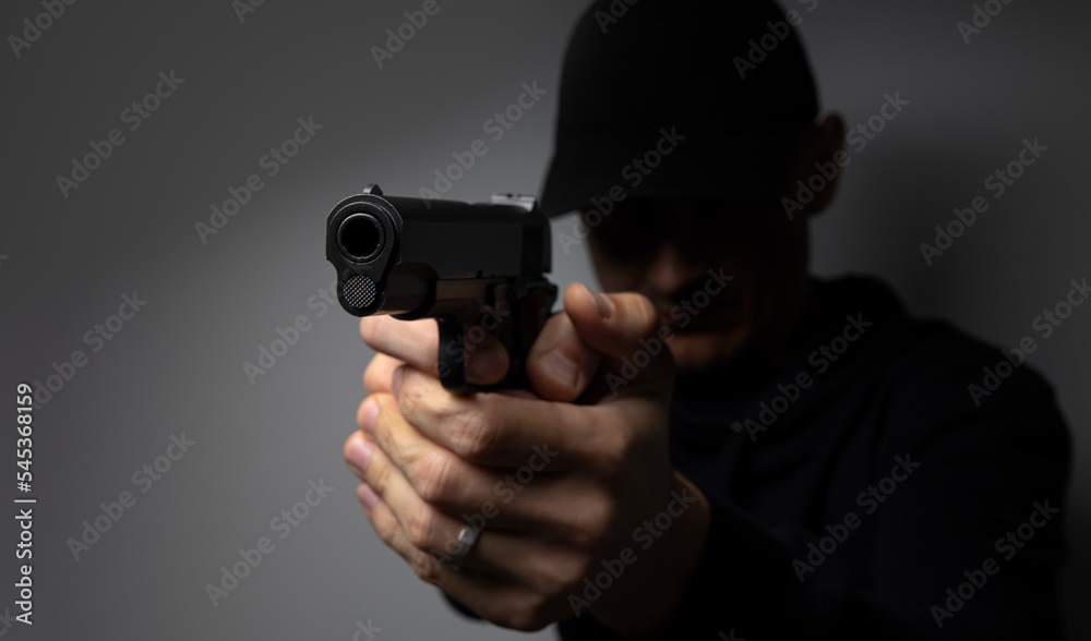 Man aiming and shooting with a gun. Focus on the pistol. Man aiming and shooting with a gun. Focus on the pistol.