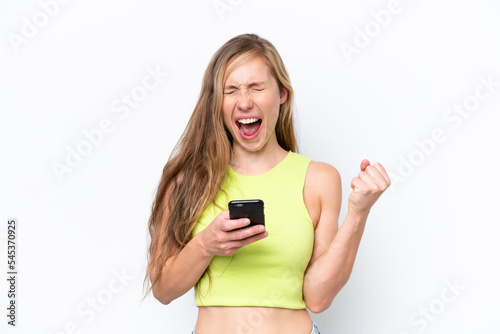 Young caucasian woman isolated on white background with phone in victory position