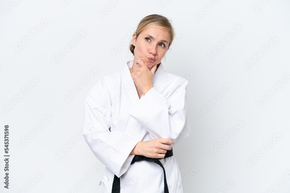 Young caucasian woman doing karate isolated on white background having doubts and thinking Young caucasian woman doing karate isolated on white background having doubts and thinking