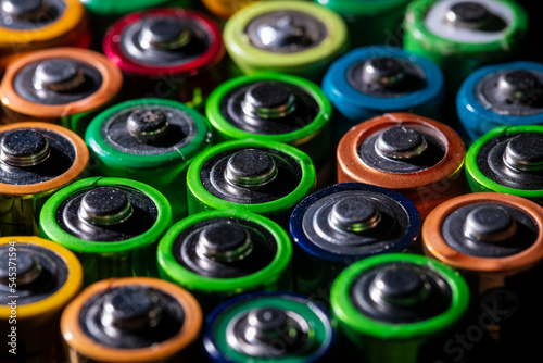 Lots of colorful discharged old batteries. Used battery on background. Hazardous garbage concept. Closeup