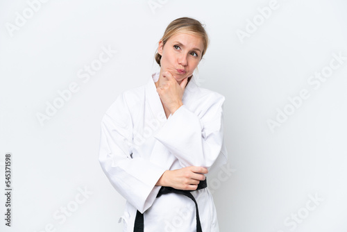 Young caucasian woman doing karate isolated on white background having doubts and thinking